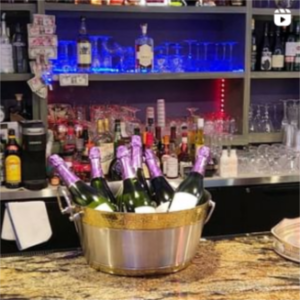 A bucket full of champagne bottles on a counter.