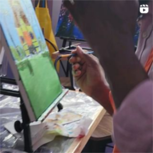 A person painting on a easel.