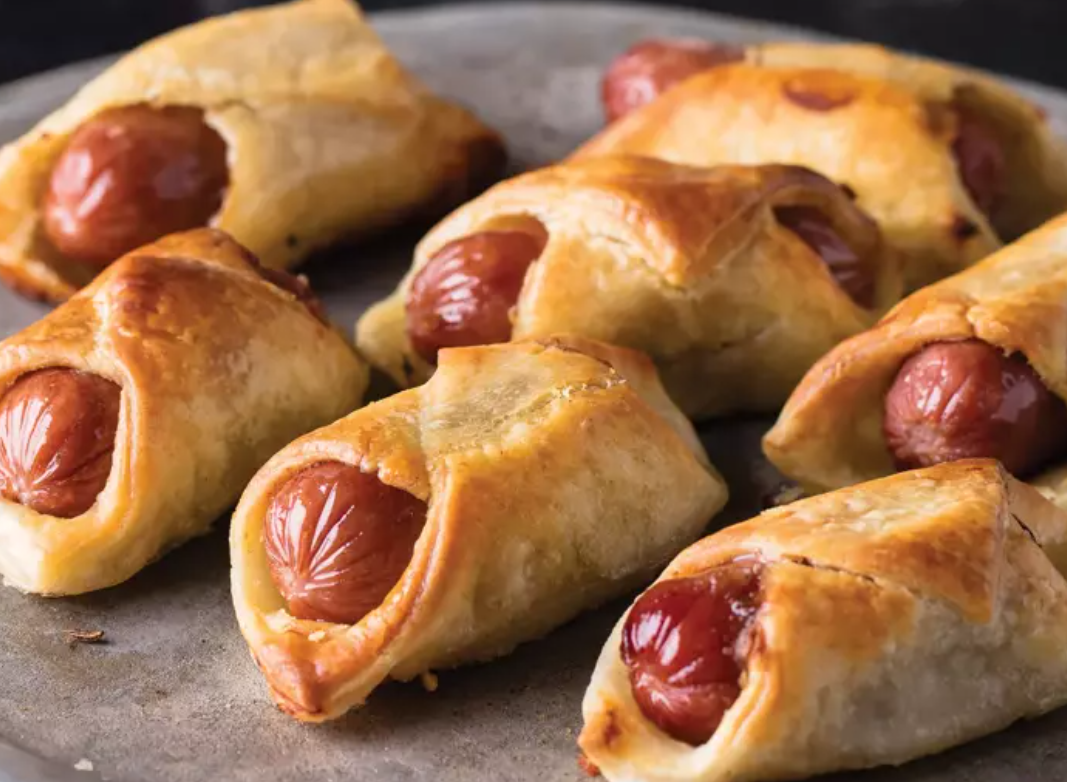 Hot dogs wrapped in pastry on a plate.