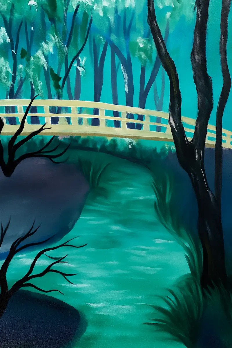 A serene blue river flowing under a white bridge surrounded by dark trees.