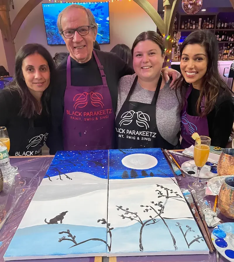 Corporate team collaborating on a mural-style team-building painting at Black Parakeetz