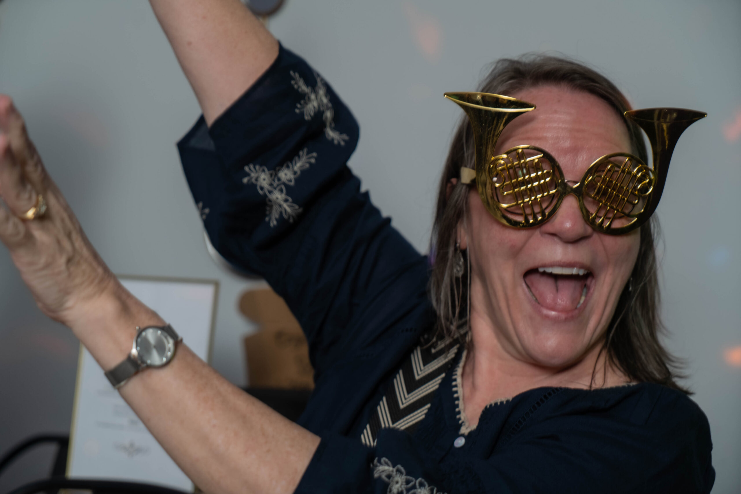 Guest celebrating in gold horn-shaped glasses at Black Parakeetz